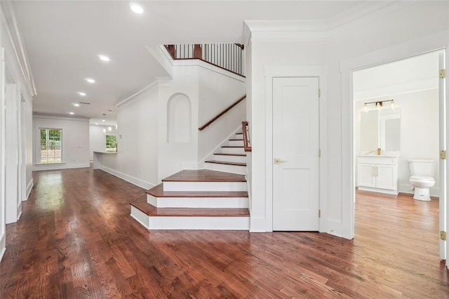 staircase featuring crown molding and hardwood / wood-style floors