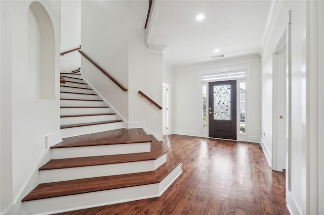 foyer entrance with hardwood / wood-style flooring and ornamental molding