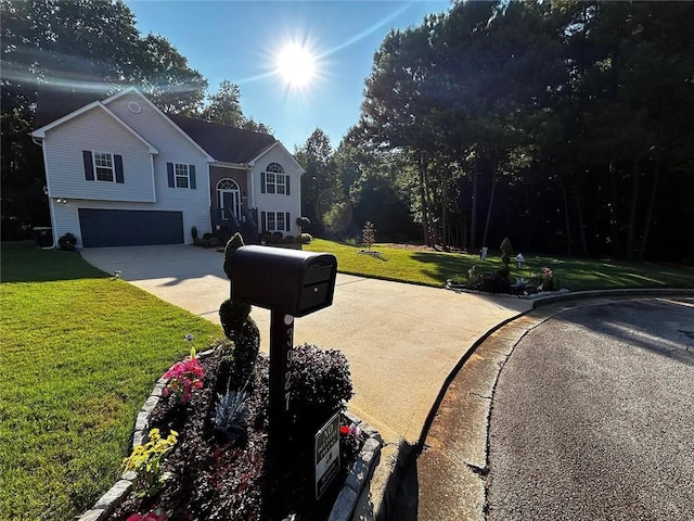 bi-level home with a front yard, a garage, and concrete driveway