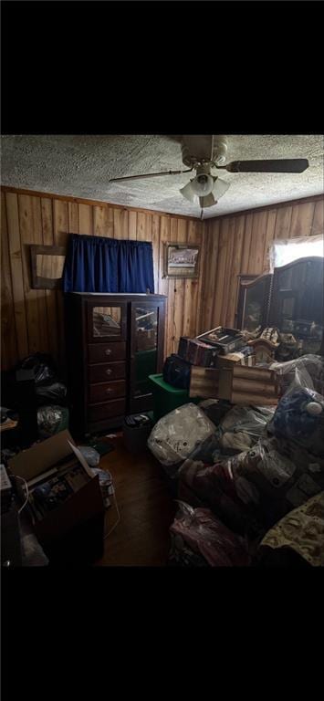 misc room featuring ceiling fan, wood finished floors, and wooden walls