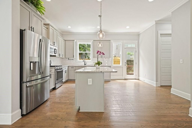 2093 Callaway Ct NW, Atlanta, GA 30318 - kitchen with appliances with stainless steel finishes, crown molding, a kitchen island, backsplash, and baseboards
