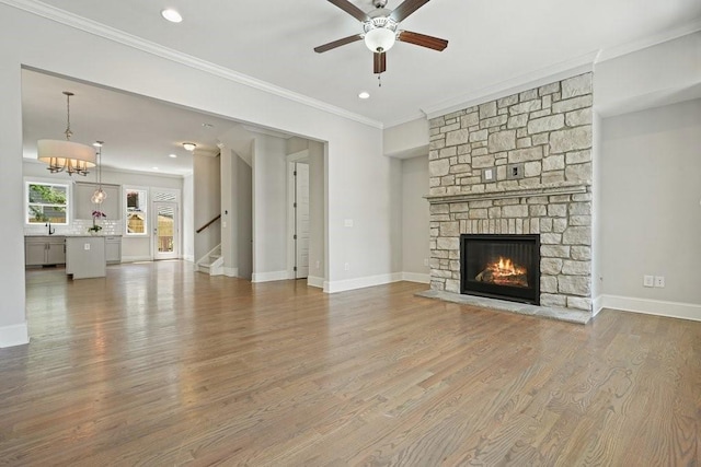 2093 Callaway Ct NW, Atlanta, GA 30318 - unfurnished living room featuring a ceiling fan, a sink, a stone fireplace, stairs, and ornamental molding
