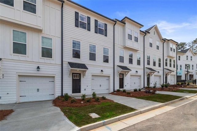 multi unit property with driveway, a garage, board and batten siding, and a residential view