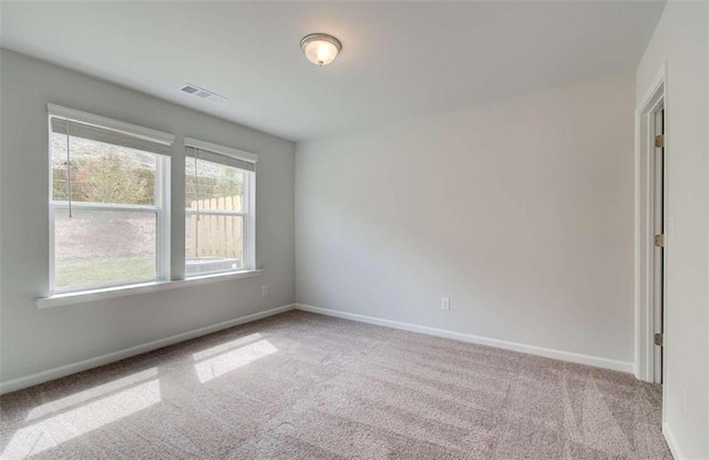 carpeted empty room featuring visible vents and baseboards