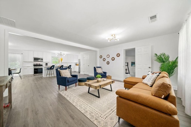 living room with hardwood / wood-style floors and a chandelier