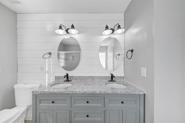 bathroom with vanity, toilet, and a shower with shower door