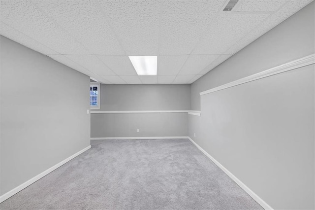 basement with carpet flooring and a paneled ceiling