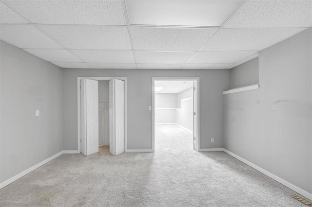 carpeted empty room featuring a paneled ceiling