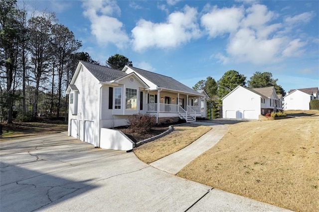 view of front facade with an outdoor structure, a front yard, a porch, and a garage