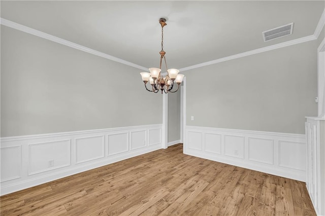 unfurnished room featuring ornamental molding, light hardwood / wood-style flooring, and a chandelier