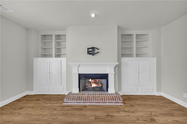 details with built in shelves and hardwood / wood-style floors