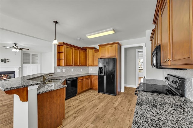 151 Chestnut Chase, Hoschton, GA 30548 - kitchen featuring black appliances, a peninsula, a sink, a ceiling fan, and dark stone countertops