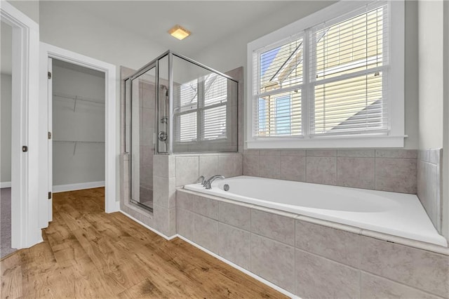 bathroom featuring wood-type flooring and separate shower and tub