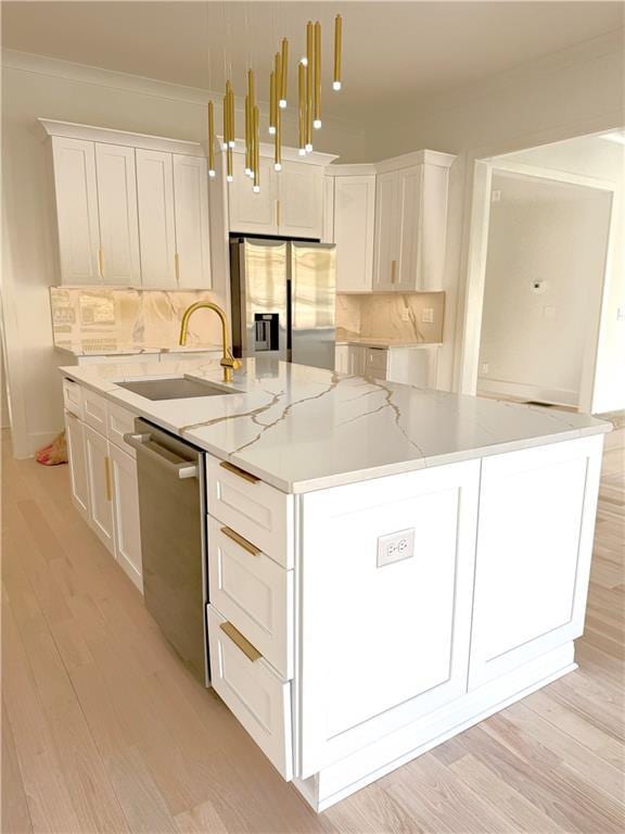 kitchen featuring sink, decorative light fixtures, a center island with sink, appliances with stainless steel finishes, and white cabinets