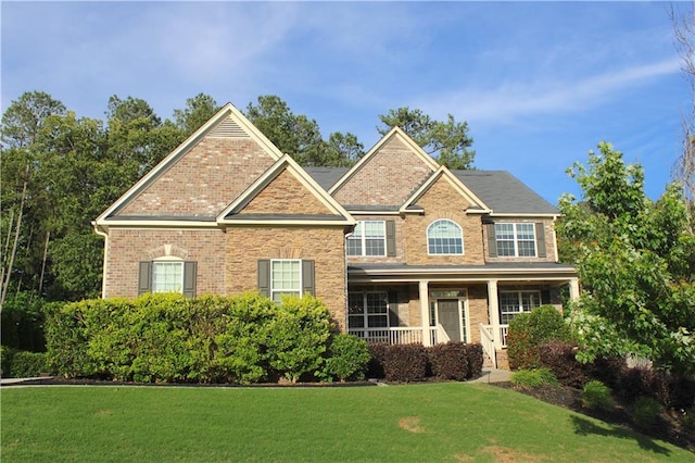 6570 Canyon Cv, Cumming, GA 30028 - view of front of property with a front yard, brick siding, and a porch