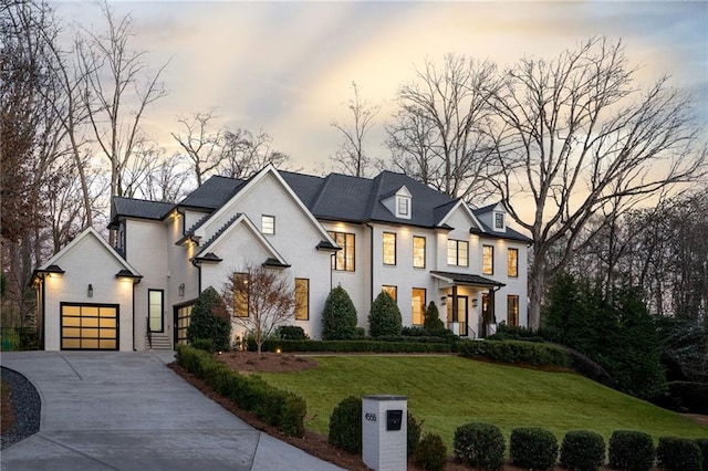 view of front of house featuring an attached garage, a front lawn, and concrete driveway