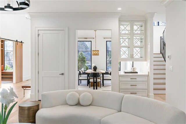 living area with light wood-style floors, recessed lighting, stairway, and ornamental molding