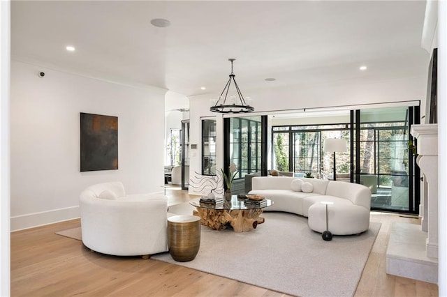 living area with light wood-style floors, recessed lighting, a chandelier, and baseboards