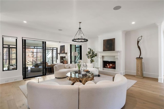 living room with light wood-type flooring, a lit fireplace, baseboards, and recessed lighting