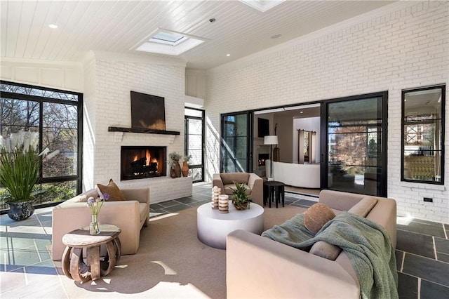 living room featuring a skylight, a fireplace, a high ceiling, wood ceiling, and brick wall