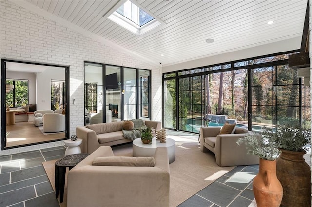 sunroom featuring vaulted ceiling with skylight and wood ceiling