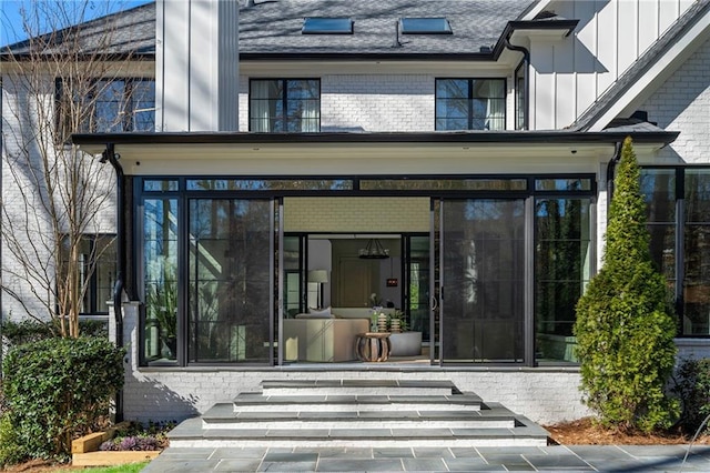 doorway to property with brick siding and board and batten siding