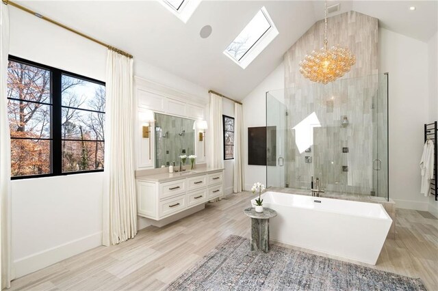 bathroom featuring a stall shower, a skylight, wood finished floors, and vanity