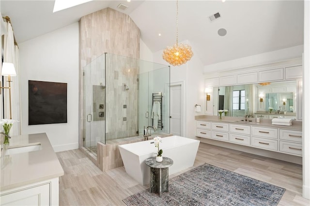 bathroom featuring high vaulted ceiling, visible vents, vanity, a freestanding bath, and a shower stall