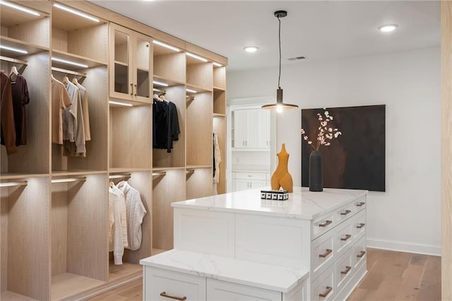 walk in closet with light wood finished floors and visible vents