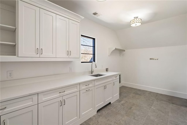 washroom featuring cabinet space, a sink, visible vents, and baseboards