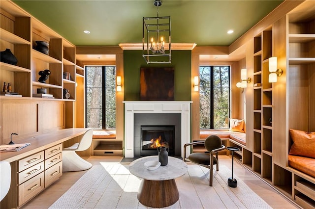 sitting room featuring light wood finished floors, a fireplace, built in study area, and recessed lighting