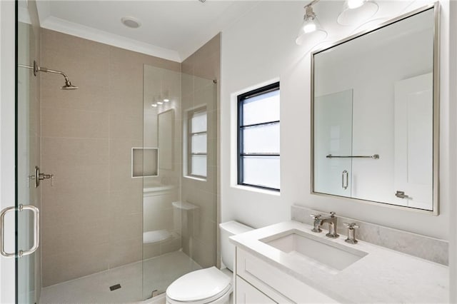 bathroom featuring vanity, ornamental molding, a shower stall, and toilet