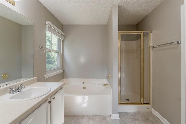 full bath with vanity, a textured ceiling, a bath, tile patterned floors, and a stall shower