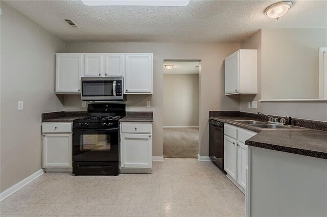 kitchen featuring a sink, dark countertops, black appliances, and white cabinetry