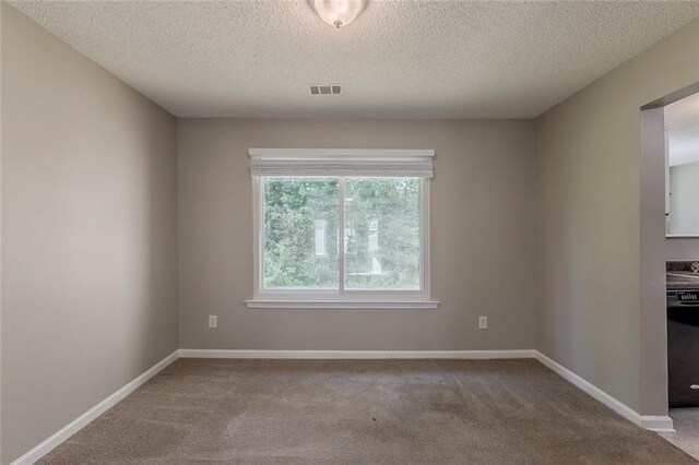 carpeted empty room with visible vents, a textured ceiling, and baseboards