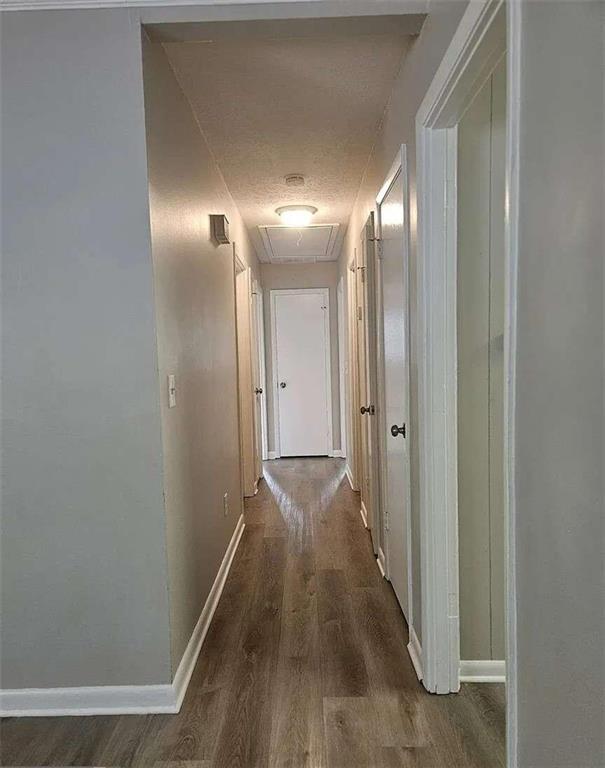 hallway featuring a textured ceiling and dark hardwood / wood-style floors