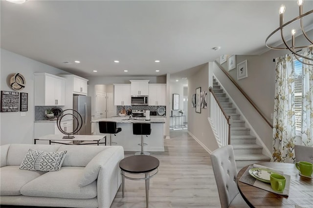 living room with a notable chandelier and light hardwood / wood-style floors