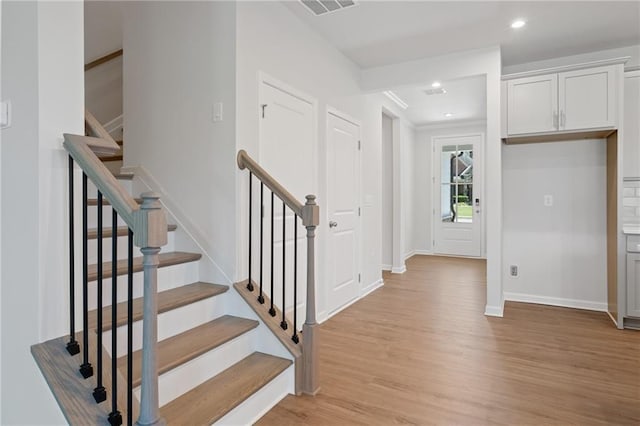 entryway featuring light wood finished floors, recessed lighting, visible vents, stairway, and baseboards