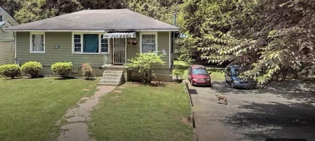 bungalow-style home featuring a front lawn