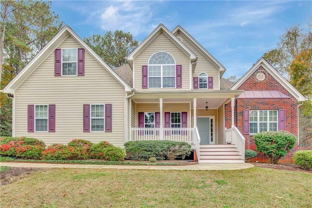 front facade featuring covered porch and a front lawn