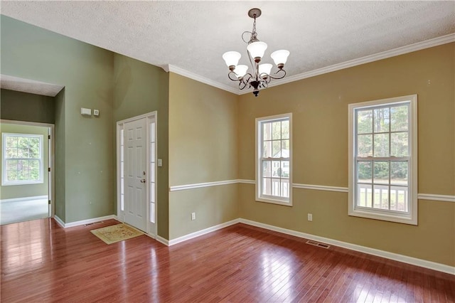 interior space featuring a chandelier, hardwood / wood-style floors, a textured ceiling, and a wealth of natural light