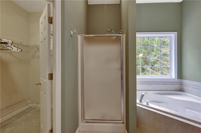 bathroom featuring a textured ceiling and independent shower and bath