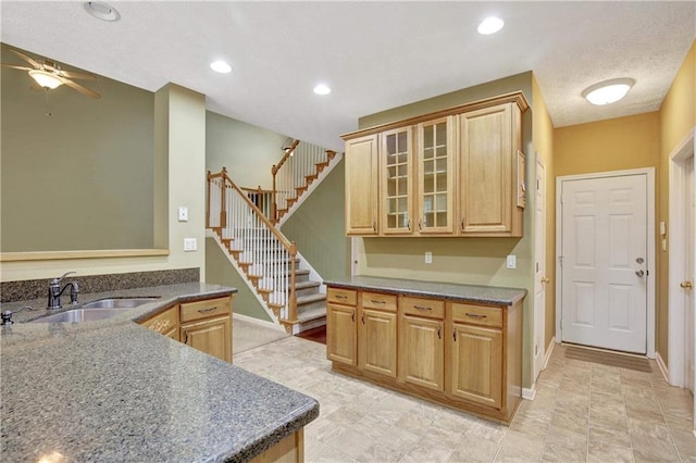 kitchen featuring kitchen peninsula, light brown cabinets, ceiling fan, and sink