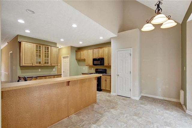 kitchen featuring a kitchen breakfast bar, sink, black appliances, pendant lighting, and lofted ceiling