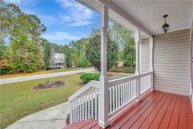 wooden deck featuring a lawn and covered porch