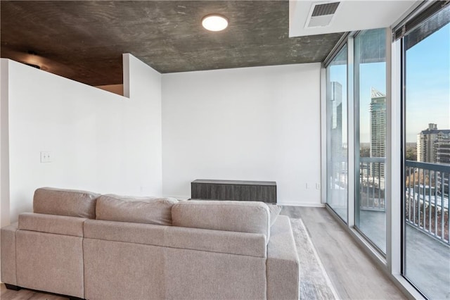 living room featuring light hardwood / wood-style flooring and a wall of windows