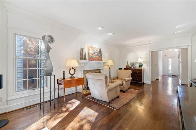 living area with ornamental molding and dark hardwood / wood-style flooring