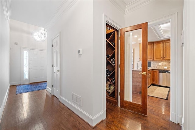 entrance foyer with crown molding and dark hardwood / wood-style floors