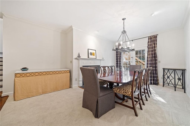 dining room with ornamental molding, light colored carpet, and a chandelier