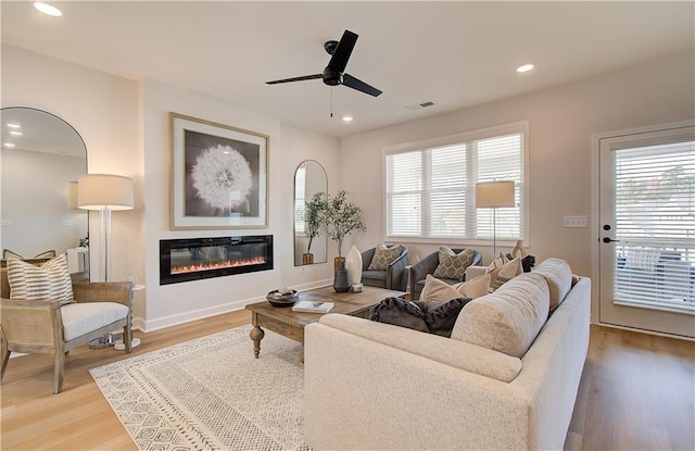 living room featuring hardwood / wood-style floors, a healthy amount of sunlight, and ceiling fan